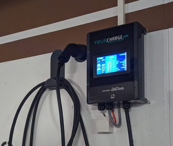 Wallbox mit Display und Steckdose in einer Tiefgarage